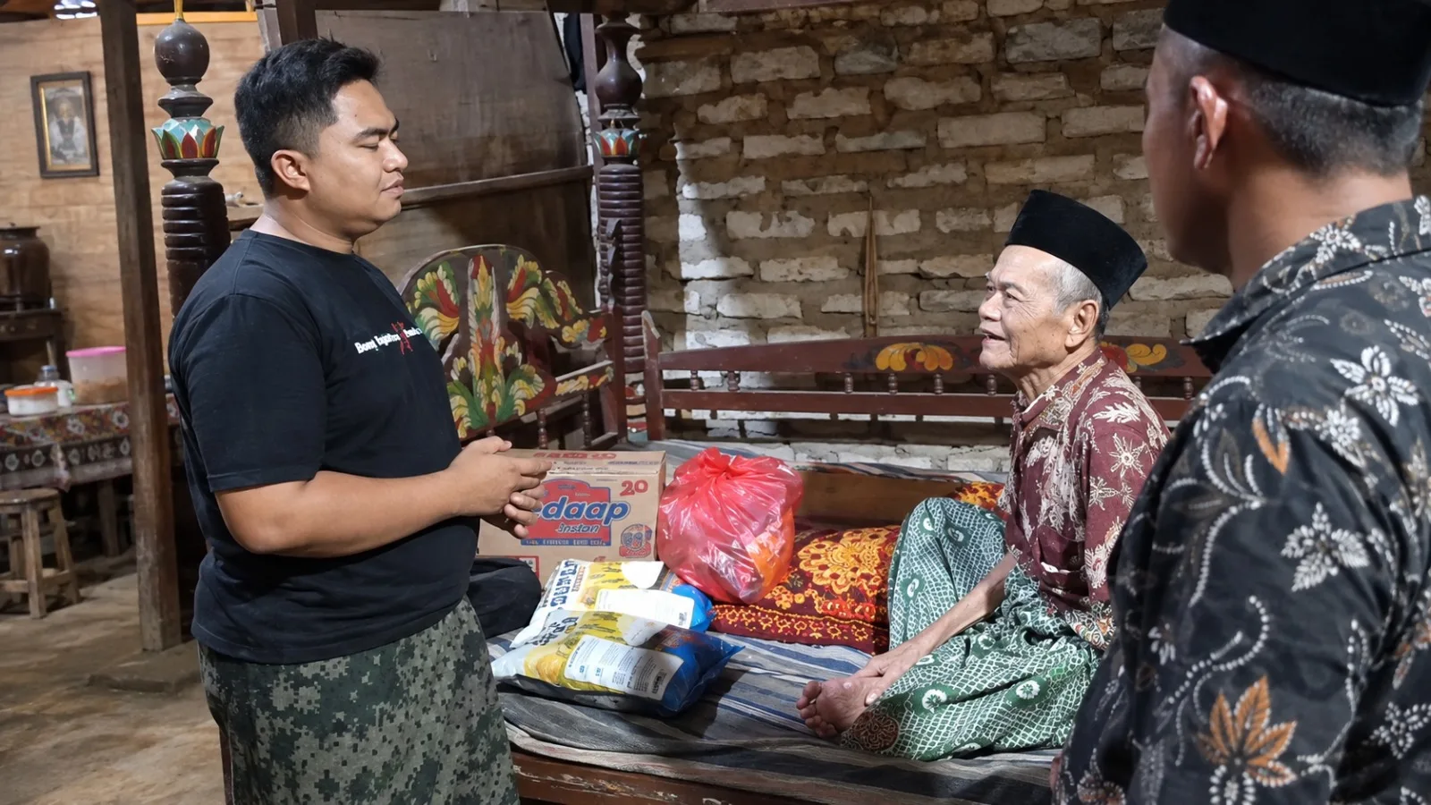 Rosi dari Yayasan Ruang Sejahtera menyerahkan bantuan kepada P. Manili di Desa Pangarengan, Sampang, pada 14 September 2026.