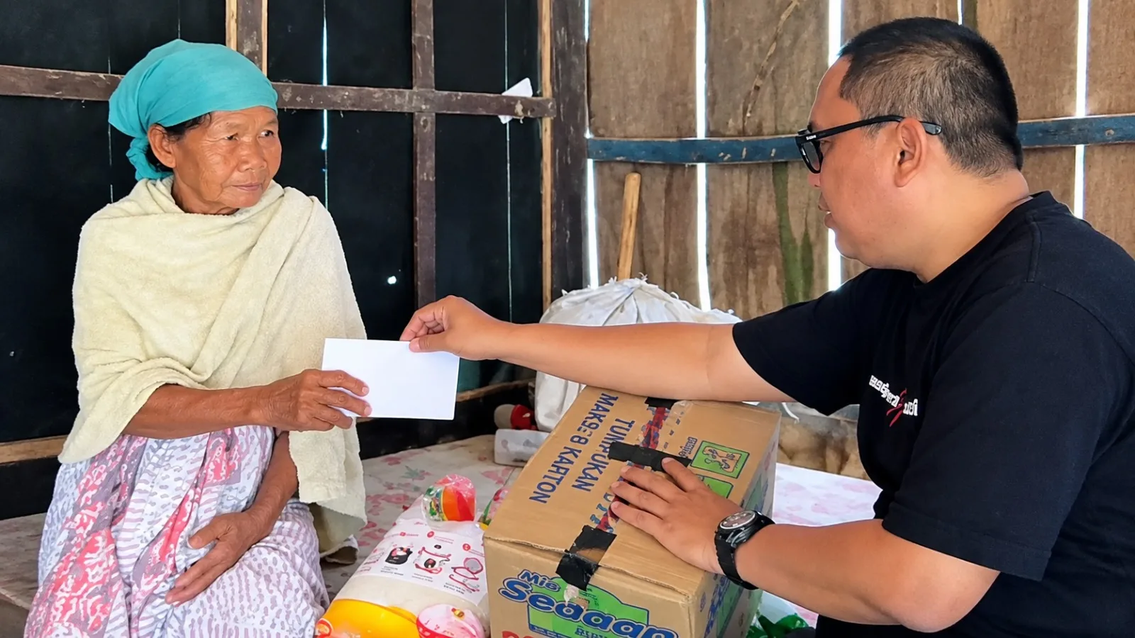 Hofid menyerahkan bantuan sembako dan uang tunai kepada Ibu Sarmadin di Dusun Bere' Songai, Desa Pandiyangan, Robatal, Sampang.